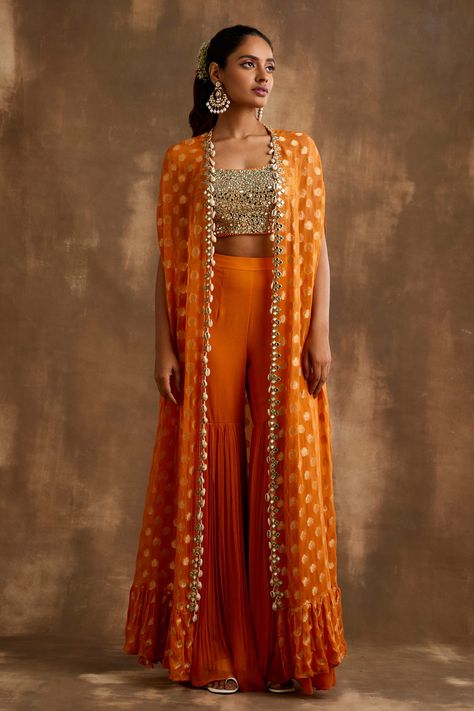 Shop for these amazing collections of Orange Georgette Embroidered Mirrorwork Floral Pattern Gharara Set For Women by Niamh By Kriti online at Aza Fashions. Orange Indian Lehenga, Orange Indo Western Outfits, Bohemian Indian Outfits, Orange Traditional Outfits, Indian Cape Outfits, Indo Western Sangeet Outfit For Women, Orange Haldi Outfit, Haldi Indowestern Outfit, Trending Indo Western Outfits