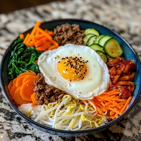 🥢 Dive into the flavors of Bibimbap! 🌶️ #KoreanCuisine #Bibimbap Bibimbap (Mixed Rice) Ingredients: Cooked rice (2 cups) Bean sprouts (1 cup, blanched) Carrot (1, julienned) Spinach (1 cup, blanched) Zucchini (1, julienned) Shiitake mushrooms (1 cup, sliced) Ground beef (1/2 cup, cooked) Kimchi (1/2 cup) Gochujang (2 tbsp) Sesame oil (1 tbsp) Sesame seeds (1 tbsp) Fried egg (1) Instructions: Arrange rice in a bowl. Place vegetables, beef, and kimchi on top. Add gochujang, sesame oil, and ... Korean Rice Bowl, Bibimbap Bowl, Kimchi Rice, Mixed Rice, Food Pic, Instagram Recipes, Korean Rice, Kimchi Fried Rice, Twisted Recipes