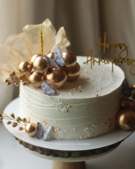 Celebrate your special moments with a touch of gold! This stunning anniversary cake, adorned with metallic spheres, delicate butterflies, and gold accents, is the perfect blend of elegance and sweetness. Whether it's for an anniversary, birthday, or any special occasion, let us craft a custom cake just for you! Ready to order? Message me on WhatsApp at 7044955912 and let's make your event unforgettable! #TheBakingMumma #AnniversaryCake #ElegantCakes #GoldAccents #CustomCakes #HomeBaker #Or... 1st Wedding Anniversary Cake, Elegant Anniversary Cakes, 50 Anniversary Cake, Simple Anniversary Cakes, 1st Anniversary Cake, Wedding Cake Simple Elegant, Wedding Cake Simple, Anniversary Cake Designs, 50th Anniversary Cakes