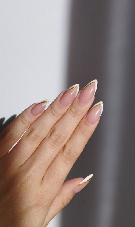 White And Gold Minimalist Nails, White French With Glitter Nails, French Tip Acrylic Nails With Gold Line, Short Almond Nails Gold French Tip, French Tip With Gold Line Nails, Almond Shape Gold French Tip, Pointy White Tip Nails, White Nail Gold Tip, White And Gold Acrylic Nails Almond