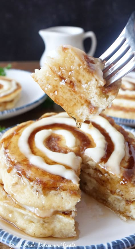 A white plate with a stack of cinnamon roll pancakes on it, with a bite being held up on a fork. Cinnamon Roll Pancakes Easy, Cinnamon Swirl Pancakes, Cinnamon Roll Pancakes Recipe, Fluffiest Cinnamon Rolls, Fluffy Buttermilk Pancakes, Yummy Pancake Recipe, Cinnamon Roll Icing, Cinnamon Filling, Cinnamon Roll Pancakes