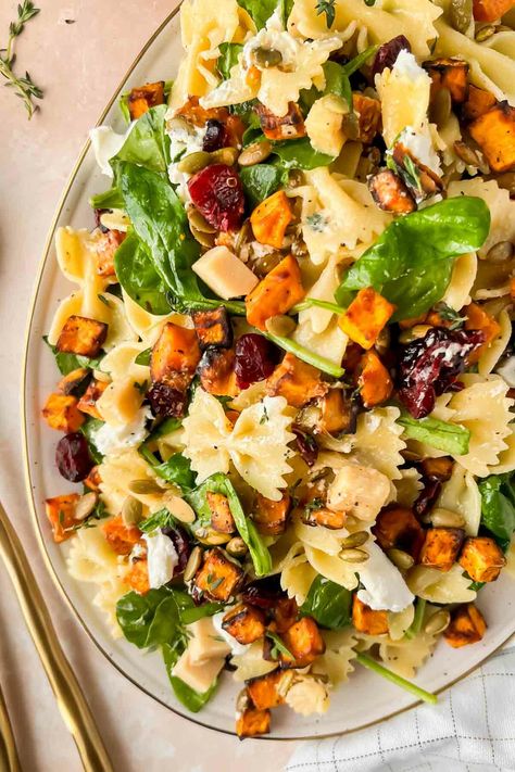 "Looking for a 30 minute recipe that is clutch for Thanksgiving, Friendsgiving, or Christmas? This is it. A fall salad loaded with roasted sweet potatoes, dried cranberries, sharp cheddar cheese, and bow-tie pasta. It feels like comfort food, without the heaviness of typical holiday foods. This easy fall harvest pasta salad convinced my fiance that ‘spinach actually is good’ – and that’s a mic drop for the delicious Maple vinaigrette dressing that coats this perfect fall salad. The Harvest Pasta Salad, Maple Vinaigrette Dressing, Thanksgiving Pasta, Fall Pasta Salad, Harvest Pasta, Winter Pasta, Fall Pasta, Maple Vinaigrette, Thanksgiving Potluck