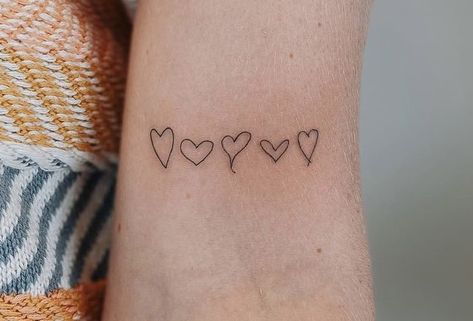 Tattoo by @vibetattoo.ut on instagram Heart Tattoos From Family, Womens Minimalist Tattoos, Dainty Tattoo Ideas For Women, Line Of Hearts Tattoo, Family Drawn Tattoo Ideas, Meaningful Family Tattoo Ideas For Women, Small Tattoo Family, Family Heart Tattoo Ideas, Small Unique Tattoos Women