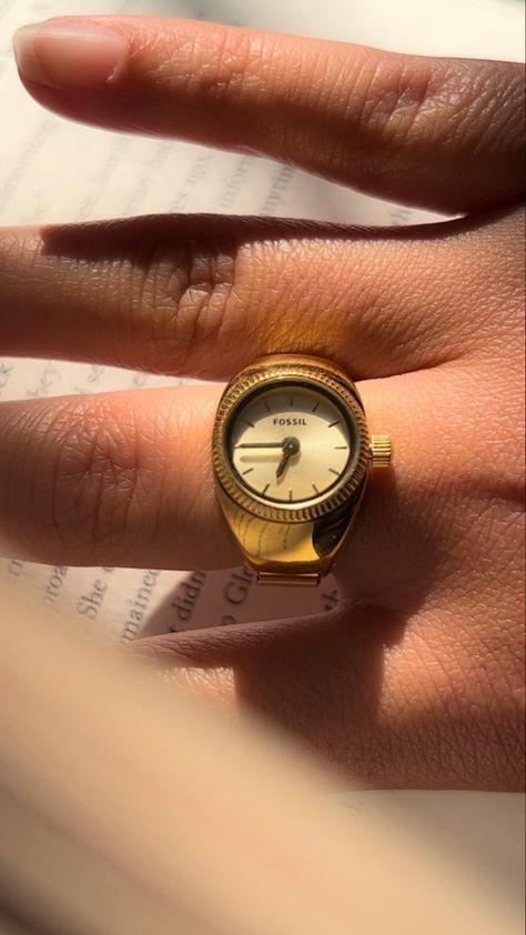 tan hand wearing a gold watch ring by Fossil. It’s a picture focused on the ring while the hand is sitting on a book Ring Watch Women, Fossil Watch Ring, Watch Rings Aesthetic, Clock Ring, Finger Watch, Ring Box Vintage, Watch Rings, Body Jewelry Diy, Vintage Gold Watch