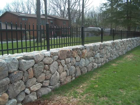 Stone Boundary Wall Design, Rock Wall With Fence On Top, Stone Perimeter Wall, Stone And Metal Fence, Stone Wall Fence Ideas, Rock Fence Ideas, Stone Wall Outdoor Fence, Fence On Stone Wall, Stone Boundary Wall