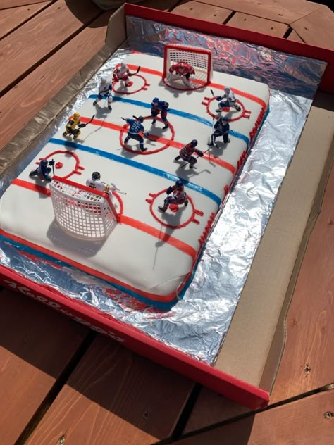 Vanilla cake base, buttercream icing topped with fondant, then we added fruit roll up for the lines and used food colouring to change the white buttercream icing to red and piped it through a bag to make the circles.  Last we added the players and nets! Hockey Party Ideas, Hockey Birthday Cake, Coach Cake, Happy Birthday Nick, Hockey Cake, Hockey Birthday Party, Hockey Cakes, Hockey Birthday Parties, Homemade Fondant