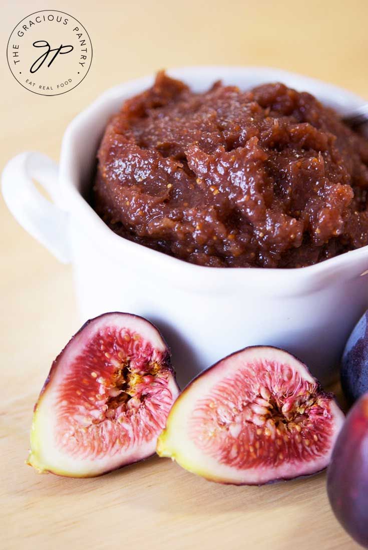 a white bowl filled with fruit next to sliced figs on a wooden counter top