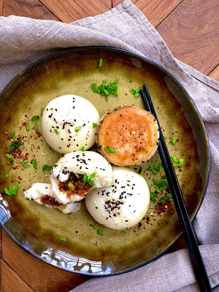 three fried eggs on a plate with chopsticks next to it and a napkin