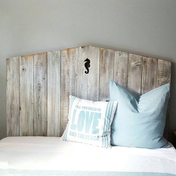 a bed with two pillows on top of it and a headboard made out of wooden planks