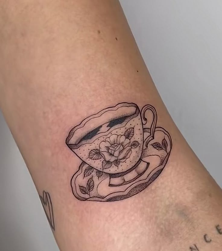 a tattoo with a tea cup and saucer on it