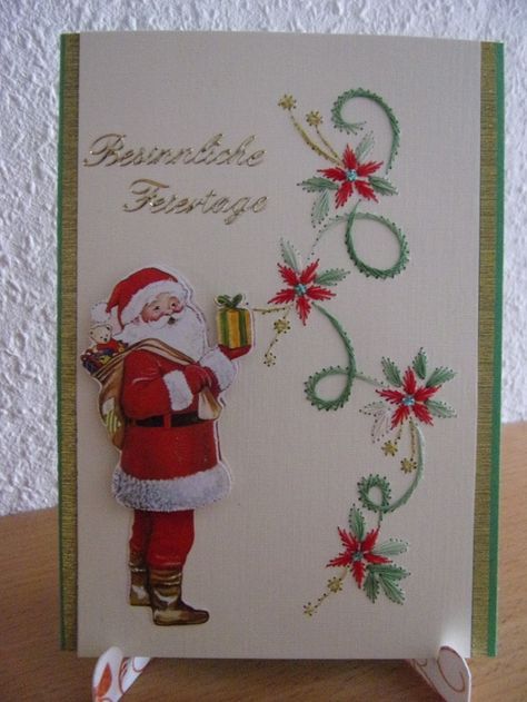 a christmas card with a santa clause holding a gift box on top of a table