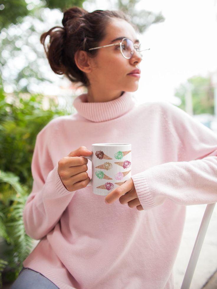 a woman in a pink sweater holding a coffee mug