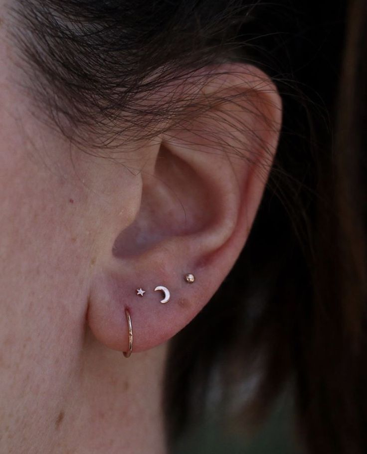 a close up of a person's ear with two piercings on it,