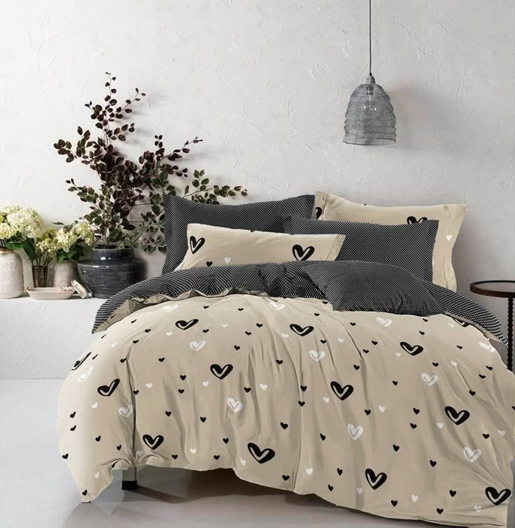 a bed with black and white hearts on the comforter, pillows and pillow cases