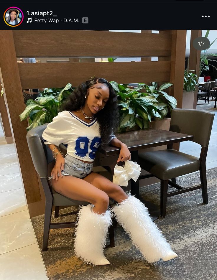 a woman sitting on top of a chair wearing white furry boots and holding a cell phone