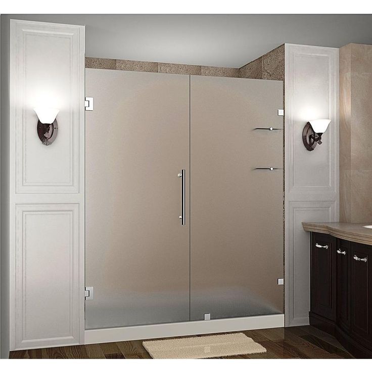 a bathroom scene with focus on the shower door and rugs in the flooring