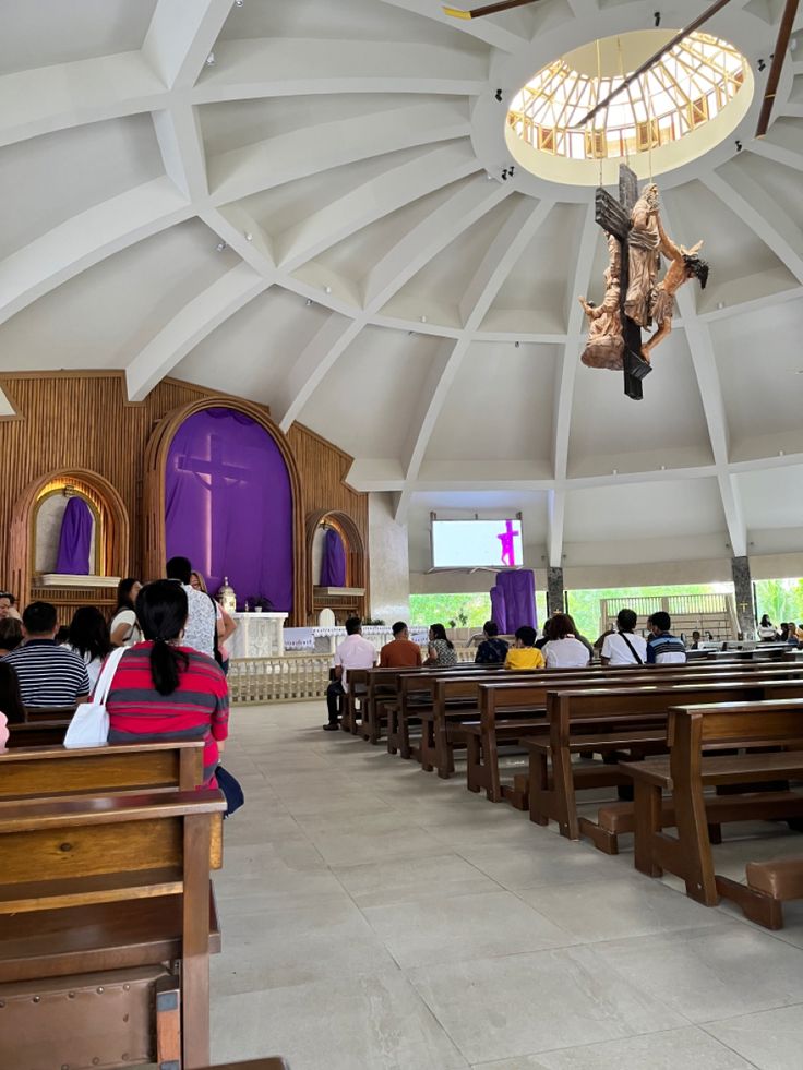 people are sitting in pews at the alter