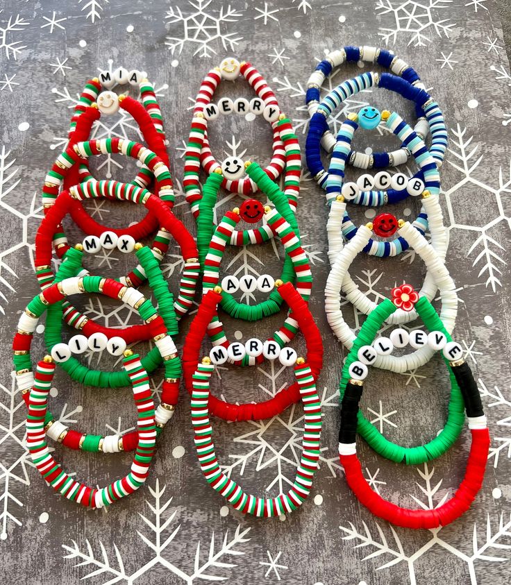 several bracelets are laid out on a table with snowflakes in the background