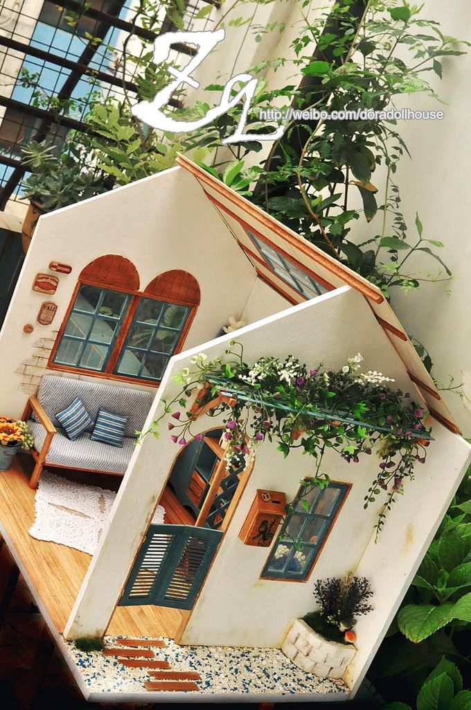 the doll house is made out of cardboard and has plants growing on it's roof