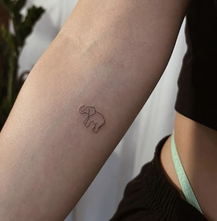 a small elephant tattoo on the arm