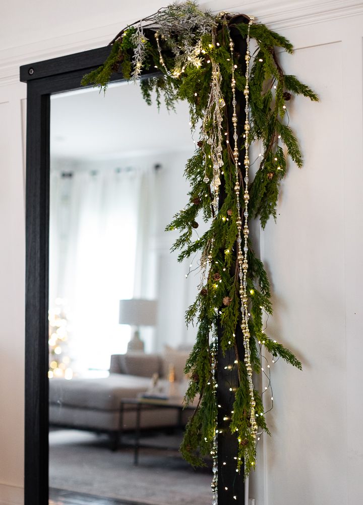 a christmas garland hanging from the side of a mirror next to a couch in a living room