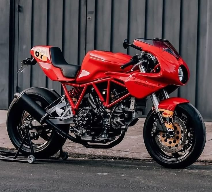 a red motorcycle parked next to a building