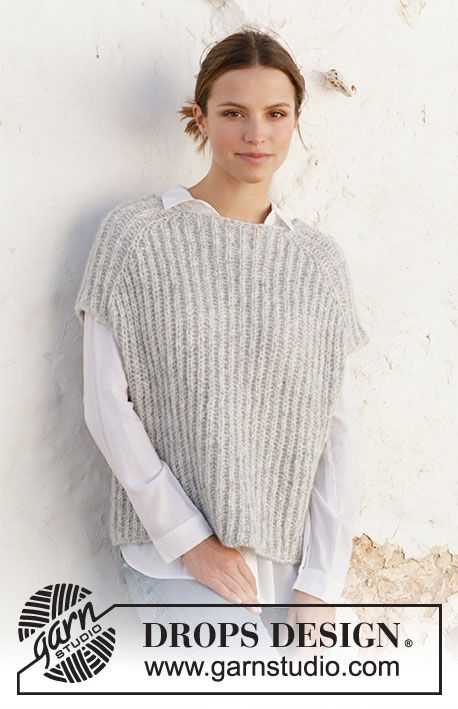 a woman standing in front of a white wall