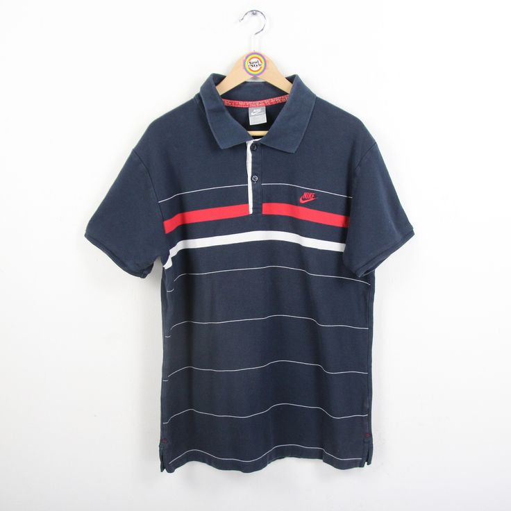 Vintage polo shirt in size XL from Nike. Although the label says size 2XL, when I tried it on it was smaller and narrower. Basic color dark blue, crossed by red / white stripes. 100% cotton. Made in Sri Lanka. You can find more t-shirts and other vintage clothes in our Etsy shop. If you have any questions, just write to us! Your soul & style from Berlin P.S.: Our clothes are vintage, so not new. We list defects that go beyond expected signs of wear (e.g. stains, missing buttons, holes, etc.) to