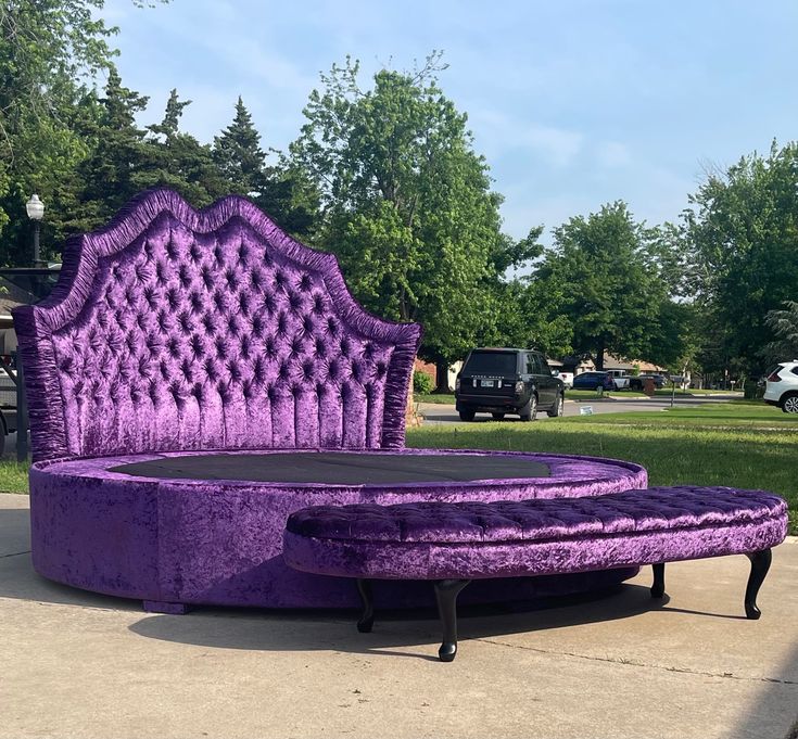 a purple bed sitting on top of a sidewalk