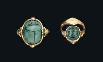 two gold rings with scarabs on them