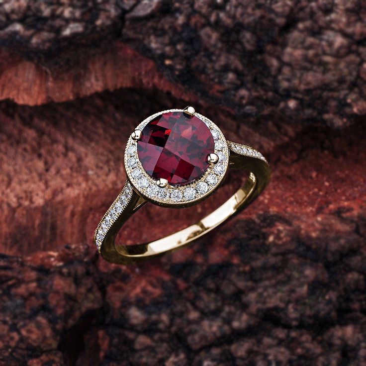 This garnet engagement ring in 14K white gold features a round garnet center stone that is complemented by brilliant white, sparkly diamond side stones. Garnet Engagement Details: 100% Handmade in the USA Center Stone - Garnet (2.00 carat AAA / VS) Metal - 100% Solid 14K (In Rose, Yellow, or White) Diamond Side Stones: Carat Weight - 0.33 carat total weight Shape - Round Cut Diamonds Color - G - H Clarity - SI1 Finger Size: We can make this setting in any finger size you need! Contact us if you Round Garnet Jewelry With Halo Setting, Luxury Garnet Ring With Center Stone, Formal Garnet Diamond Ring With Accent Stones, Formal Garnet Birthstone Ring With Center Stone, White Gold Ruby Ring With Garnet Center Stone, Diamond Ring With Center Stone And Lab-created Ruby, Lab-created Ruby Diamond Ring With Accent Stones, Fine Jewelry Round Cluster Ring With Garnet, Round Diamond Ring With Center Lab-created Ruby