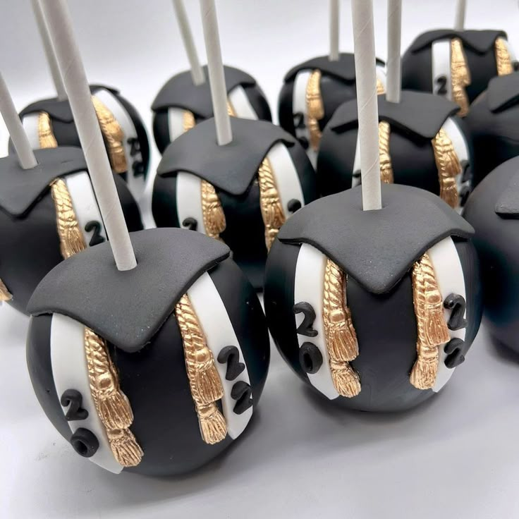 some black and white cake pops with gold trimmings are arranged on top of each other