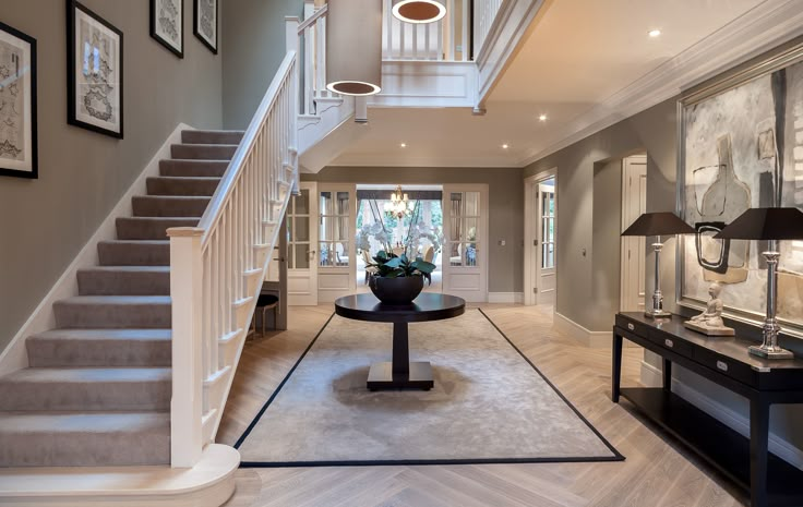 an image of a home with stairs and pictures on the front wall, along with carpeted flooring