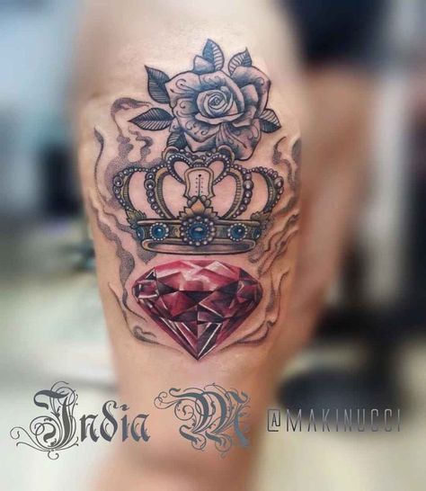 a woman's leg with tattoos on it and a crown in the middle, surrounded by jewels