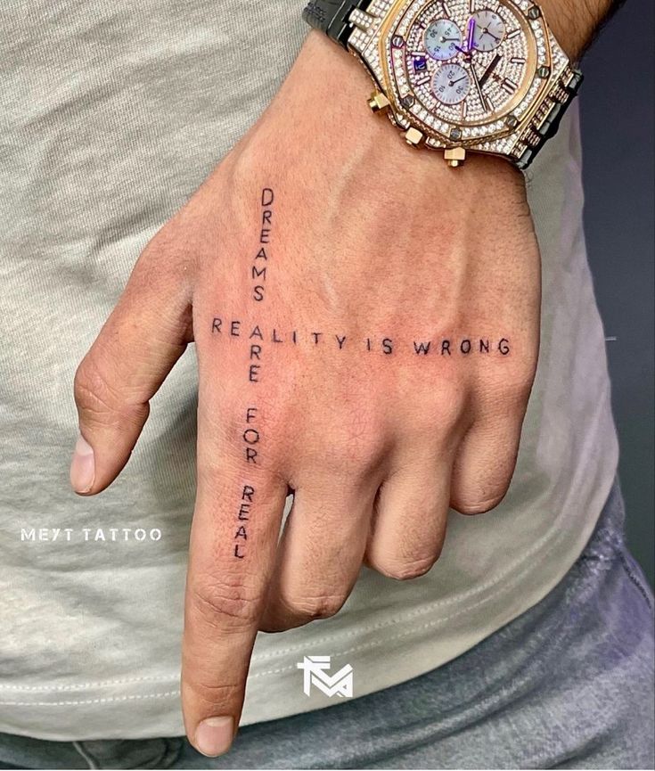 a person with a wrist tattoo that says reality is wrong