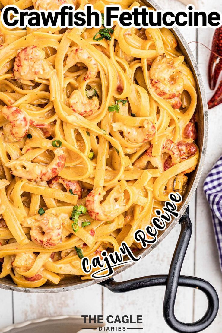 a pan filled with pasta and shrimp on top of a wooden table