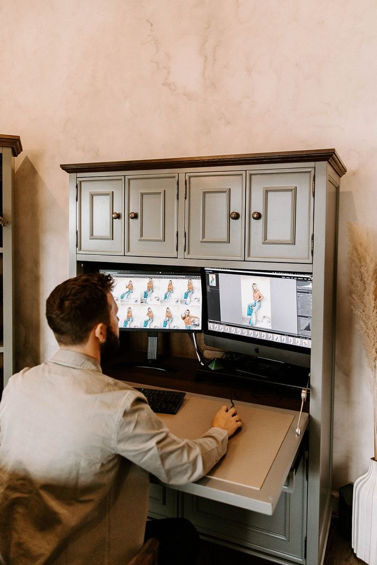 a man sitting at a desk with a computer monitor and keyboard in front of him