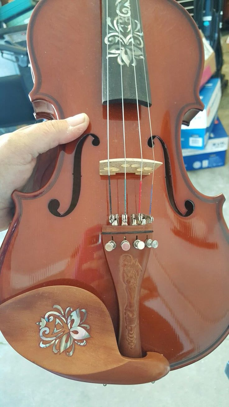 a violin being held up by someone's hand