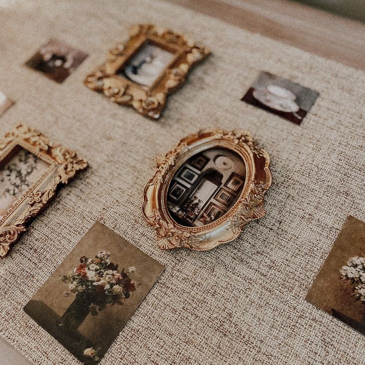 there are many pictures and frames on the table