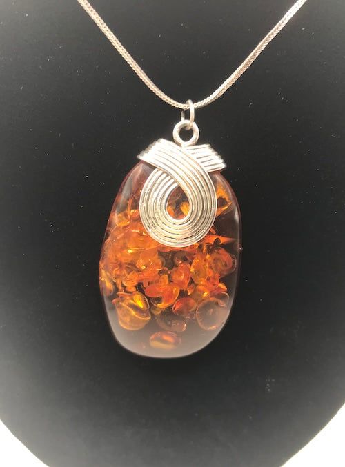 This exquisite necklace, set in sterling silver, is adorned with the finest and most valuable amber in the world - a captivating specimen originating from the Baltic Sea. Its classic Italian chain adds a touch of timeless elegance. For those seeking a jewelry piece of significance, this magnificent pendant is the perfect choice. Since antiquity, Baltic amber has been held in high regard for its unparalleled beauty, warmth, and magical luster. Sterling Silver Chain: 20" (1.25mm) sterling silver I Hallmarked Amber Round Necklace, Classic Amber Pendant Necklace, Handmade Baltic Amber Necklace In Brown, Handmade Brown Baltic Amber Necklace, Formal Oval Amber Necklace, Classic Amber Necklace As Gift, Classic Amber Necklace Gift, Classic Amber Necklace For Gift, Amber Necklace With Large Pendant For Formal Occasions