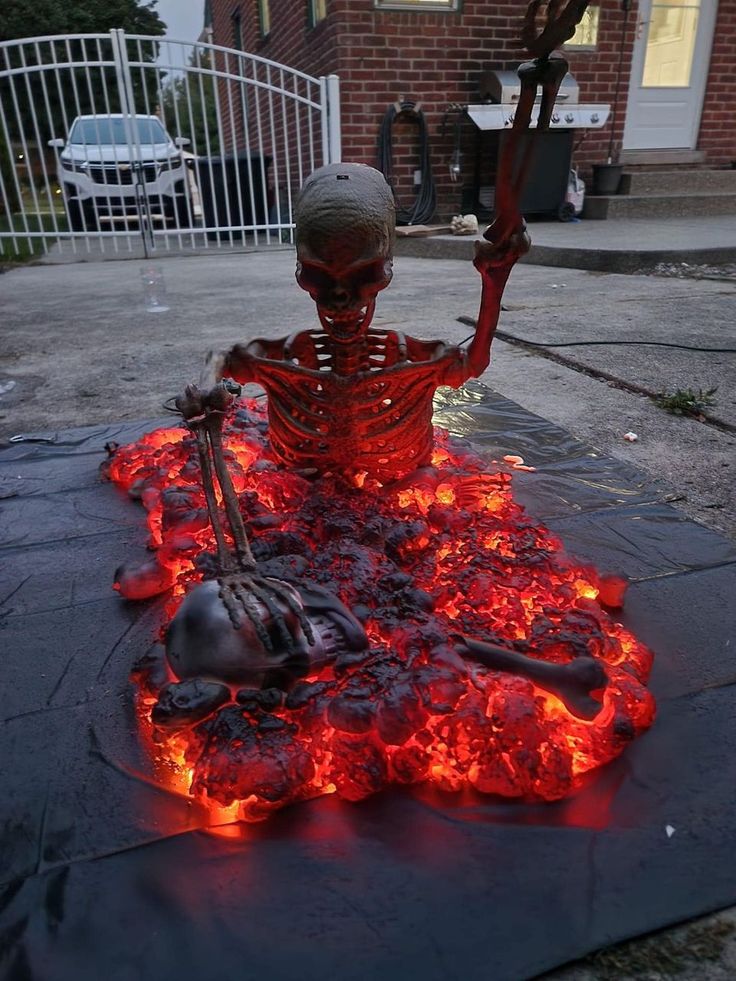 a fake skeleton sitting on top of a fire pit