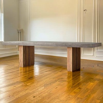 an empty room with wood flooring and white walls, along with a bench in the middle