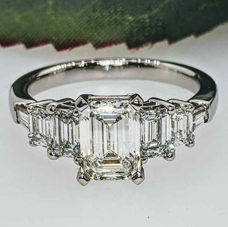 an emerald cut diamond ring with three baguets