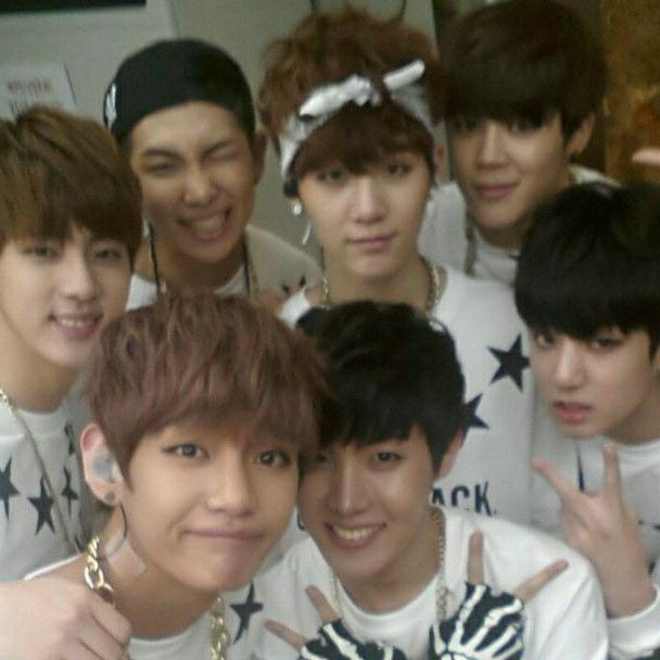 the group of young men are posing together for a photo with their hands in the air