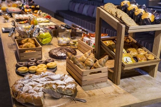 a wooden table topped with lots of different types of pastries and desserts next to each other