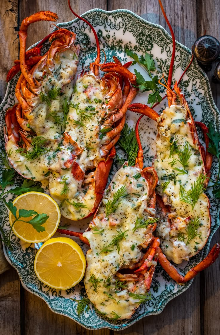 cooked lobsters on a platter with lemon wedges and parsley garnish