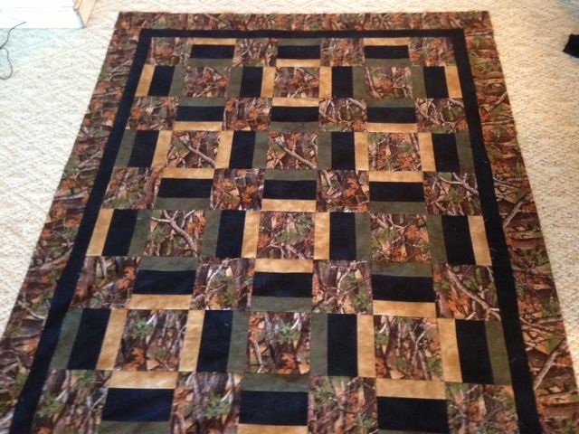 a black and brown quilt on the floor