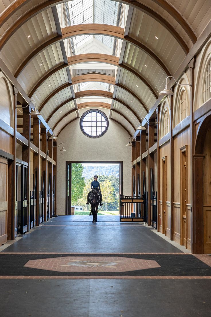 a person is walking down the hallway in an old building with arched windows and doors