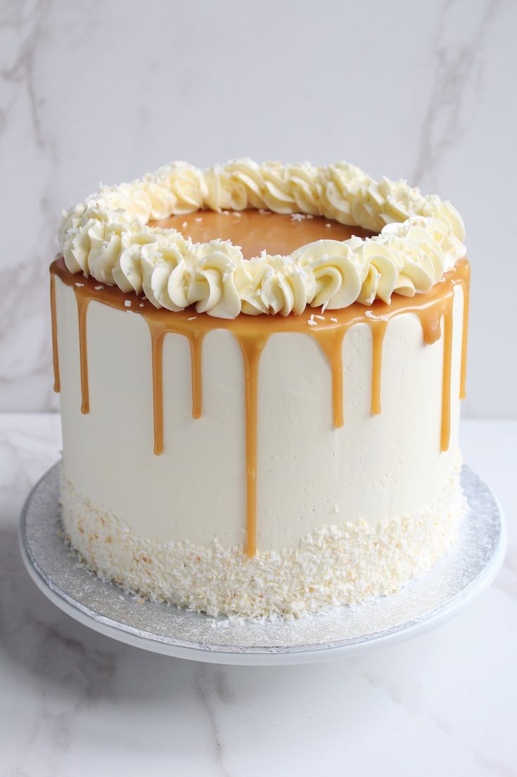 a cake with white frosting and caramel drizzle on top