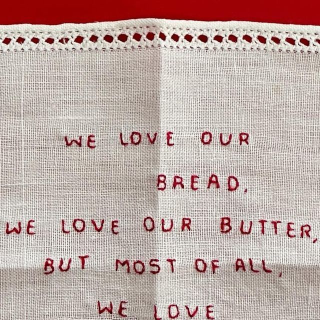 a piece of cloth with writing on it that says we love our bread, we love our butter, but most of all we love